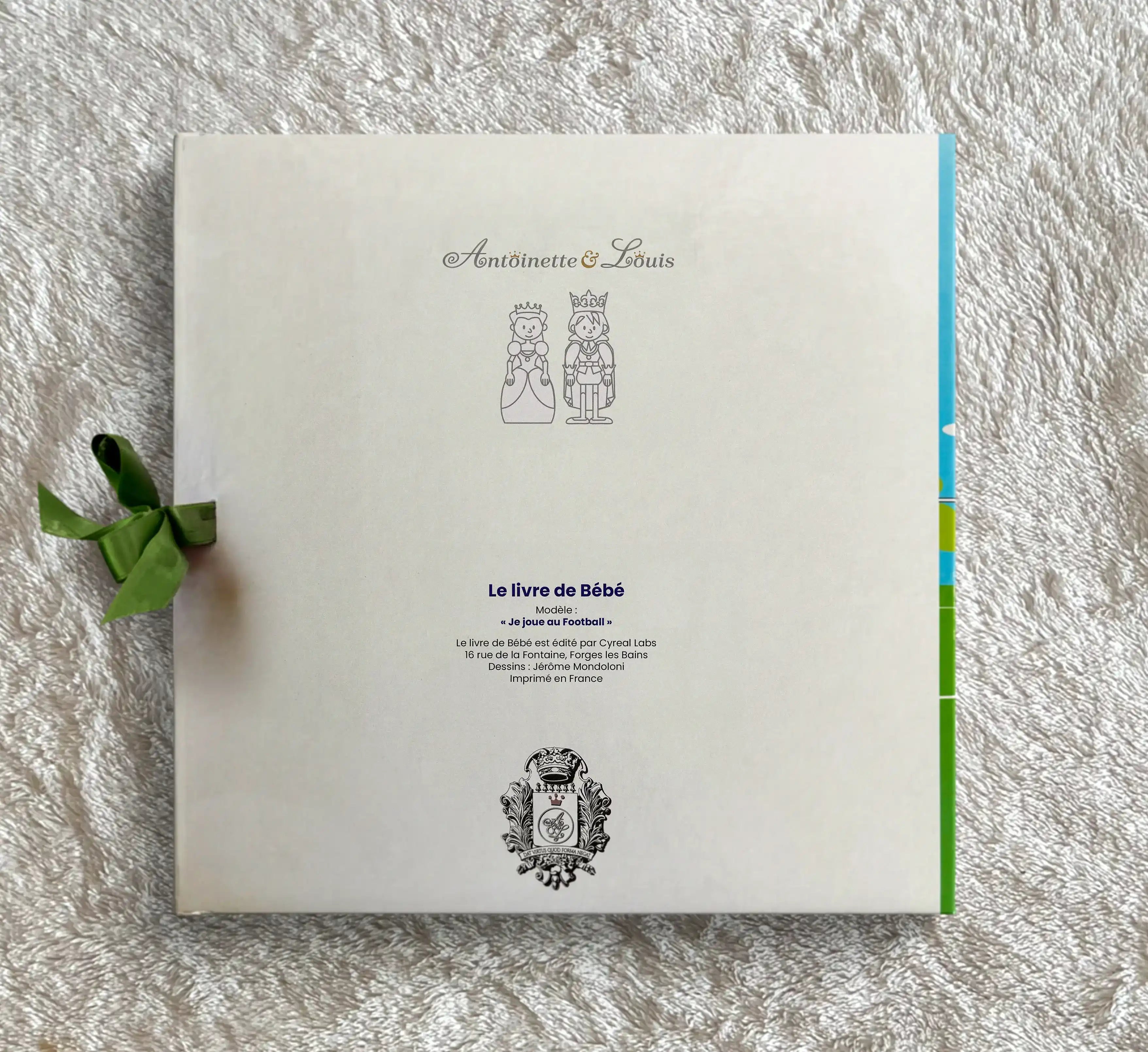Dos de l’album de naissance foot Antoinette & Louis avec ruban vert et logo de la marqu