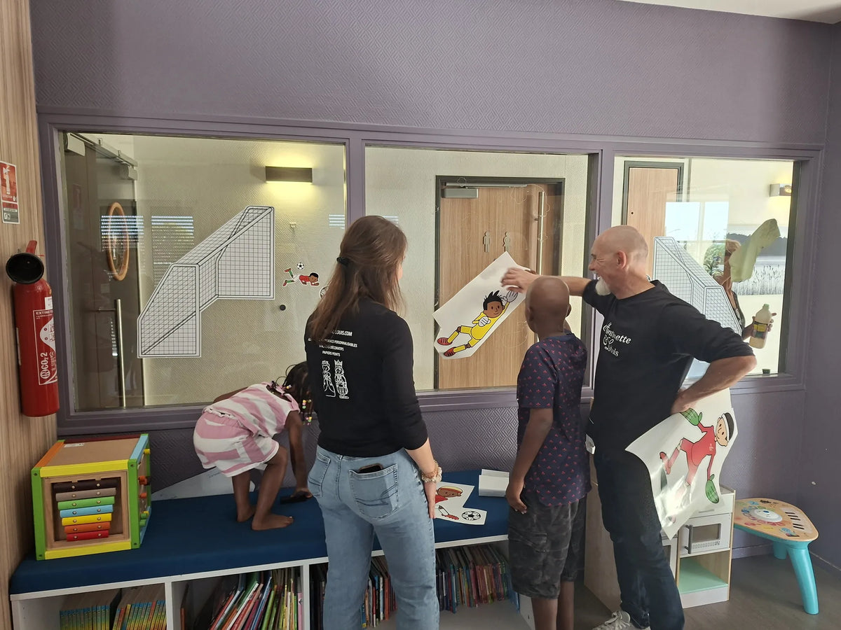 Cyrielle et Stéphane posent des stickers muraux avec des enfants à la Maison des Parents Ronald McDonald de Villejuif
