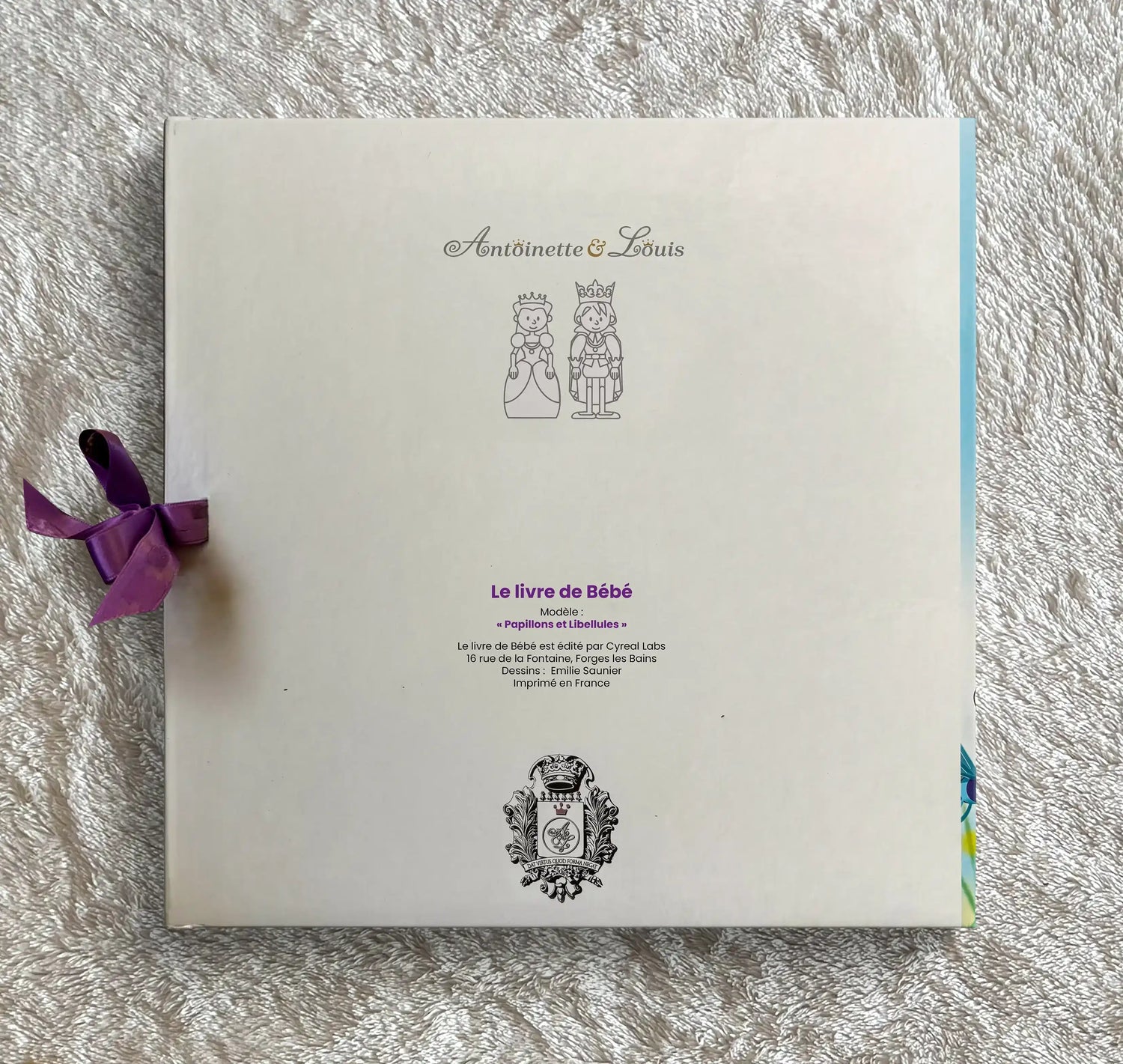 Dos de l’album photo naissance Antoinette &amp; Louis, modèle papillons et libellules, avec ruban violet et logo de la marque imprimé en France