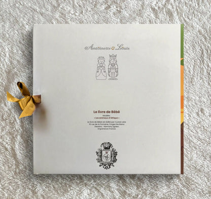 Dos de l’album photo naissance Antoinette &amp; Louis, modèle jungle, avec ruban violet et logo de la marque imprimé en France