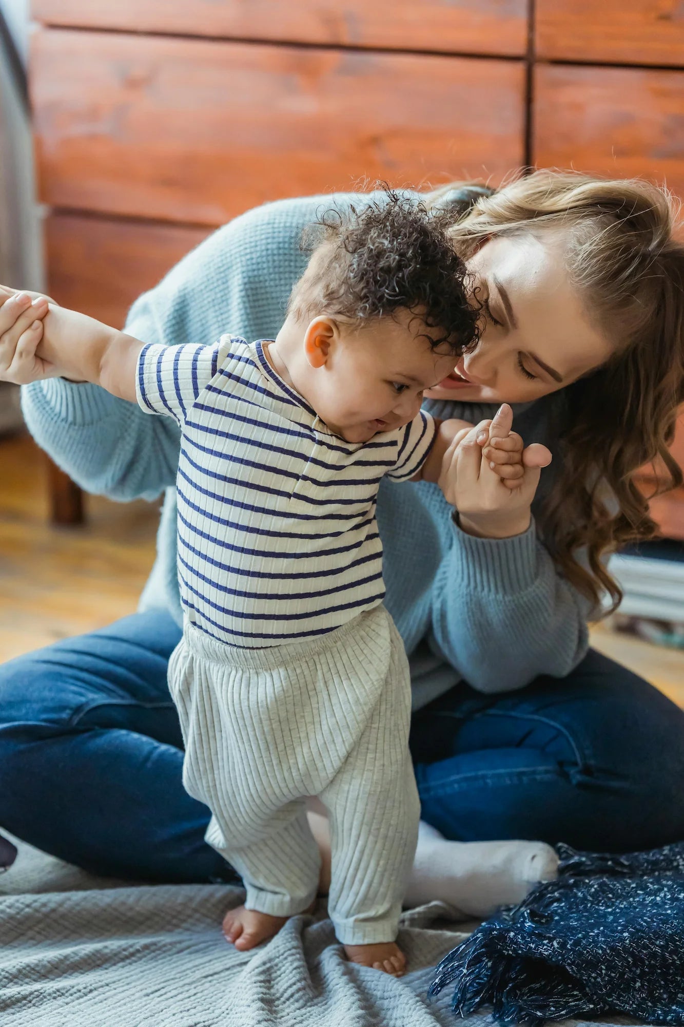 Petit garçon qui fait ses premiers pas aidé de sa maman. Antoinette & Louis