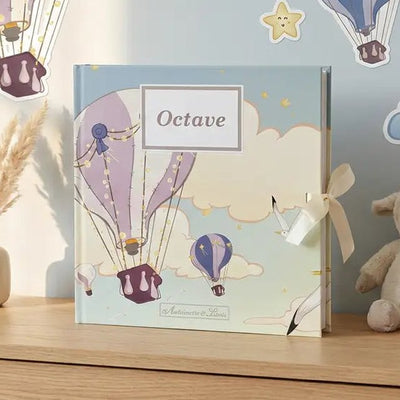 Album photo naissance Montgolfière personnalisé posé sur une commode avec des stickers muraux