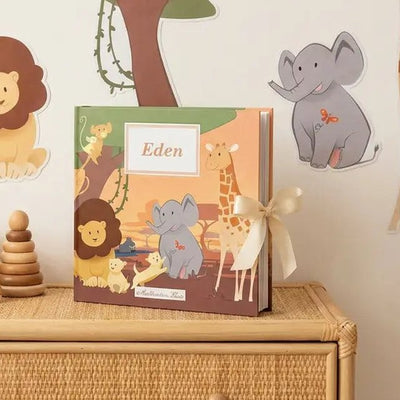 Album photo naissance Jungle personnalisé avec le prénom Eden, posé sur une commode avec des stickers muraux jungle
